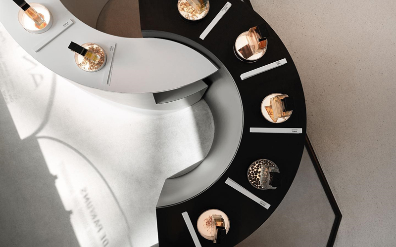 un mobilier noir et blanc en spirale présentant les flocons de parfum vu de haut